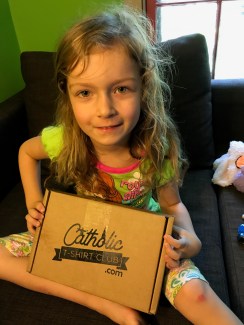 Rosie with the Catholic T-Shirt Club box